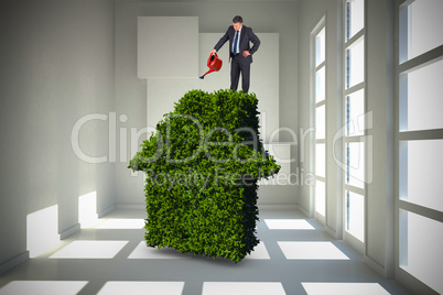 Composite image of mature businessman using watering can