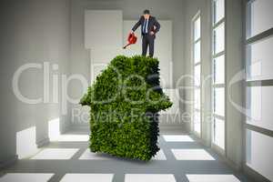 Composite image of mature businessman using watering can