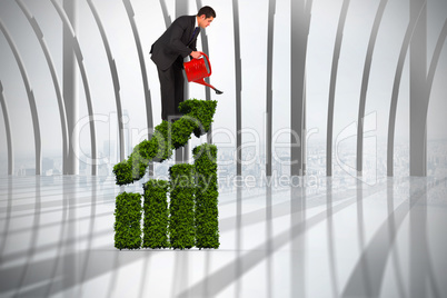 Composite image of businessman watering with red can