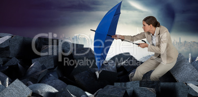 Composite image of full length of businesswoman defending with blue umbrella