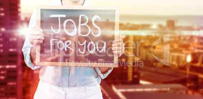 Composite image of businesswoman holding signboard with text jobs for you