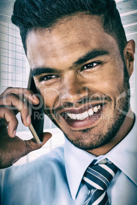 Composite image of smiling businessman talking on smart phone