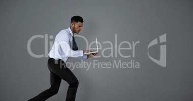 Composite image of businessman using laptop while running