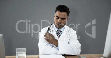 Composite image of doctor looking medical report at desk