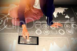 Composite image of low section of businesswoman using digital tablet on white background