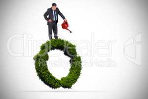 Composite image of mature businessman using watering can