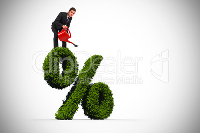 Composite image of businessman watering with red can