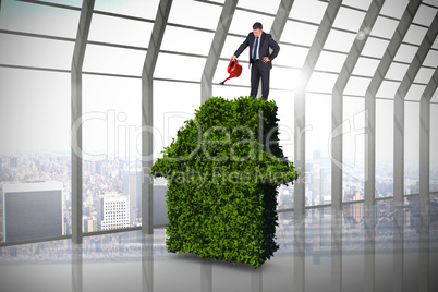 Composite image of mature businessman using watering can