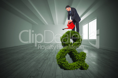 Composite image of mature businessman using watering can