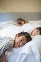 Siblings sleeping on bed in bedroom