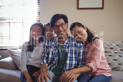 Smiling family relaxing on sofa in living room