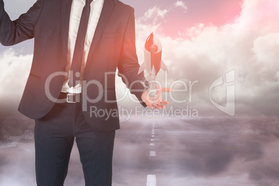 Businessman is holding a rocket taking off from his hand against sky background