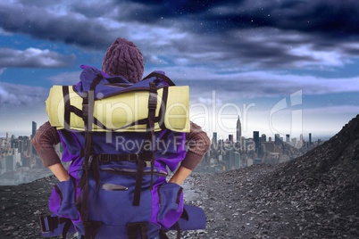 Traveler carrying bag looking at landscape from the back against cityscape background