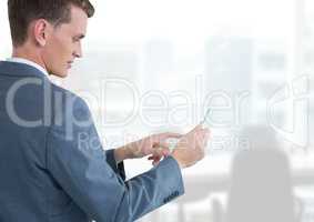 Businessman holding glass tablet in bright office