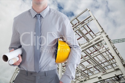 Architect close to a building with his hard hat and plans