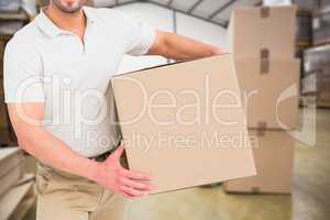 Delivery man with box in warehouse