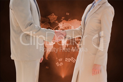 Handshake between a business man and a businesswoman against world wide map background