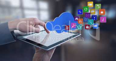 Businessman touching tablet with app icons and cloud in wide room towards windows