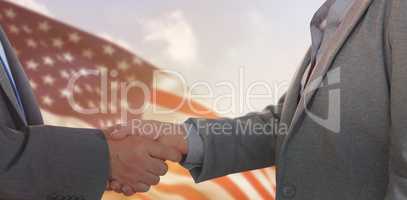 Composite image of close up on two businesspeople shaking hands