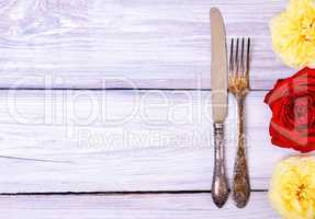 Iron cutlery fork and knife on a white wooden table