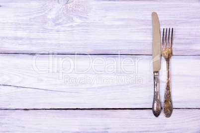 Iron fork and knife on a white wooden background