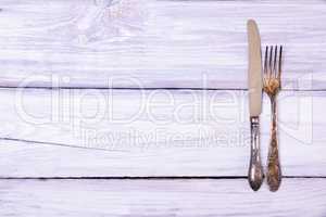 Iron fork and knife on a white wooden background