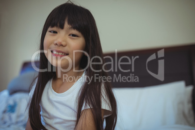 Smiling girl sitting on bed in the bed room