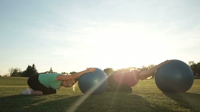 Adult women working out in park with fitness balls