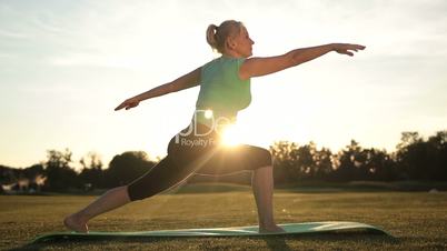Adult healthy woman practicing yoga at sunset