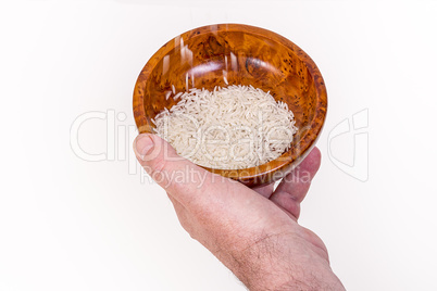 Hand holding wooden bowl with rice