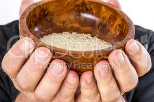 Hand holding wooden bowl with rice
