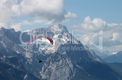 Gleitschirmflieger vor der Zugspitze in Bayern