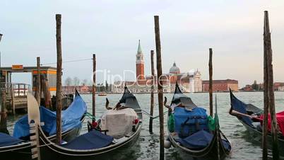 Parked gondolas sway on the waves in Venice