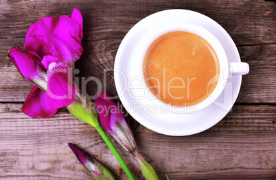 Cup of cappuccino and violet blossoming iris