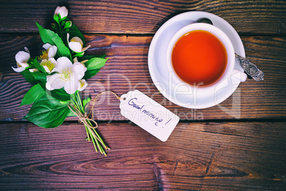 cup of tea and a bouquet of blossoming jasmine with a paper tag