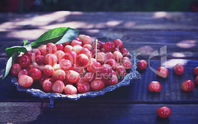 Ripe pink cherry in an iron plate