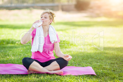 Young Fit Adult Woman Outdoors On Her Yoga Mat with Towel Drinki