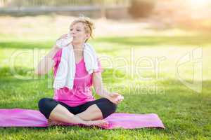 Young Fit Adult Woman Outdoors On Her Yoga Mat with Towel Drinki