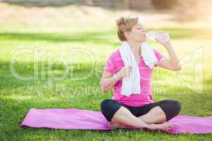 Young Fit Adult Woman Outdoors On Her Yoga Mat with Towel Drinki