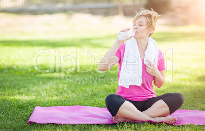 Young Fit Adult Woman Outdoors On Her Yoga Mat with Towel Drinki