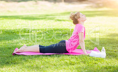 Young Fit Adult Woman Outdoors on The Grass Doing the Upward Dog