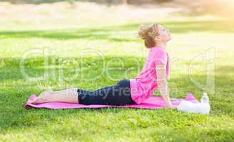 Young Fit Adult Woman Outdoors on The Grass Doing the Upward Dog