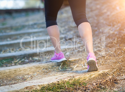 Young Fit Adult Woman Outdoors Walking or Running Up Wooden Step