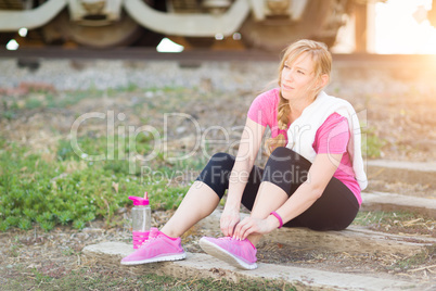 Young Adult Woman Outdoors With Towel and Water Bottle Tying Her