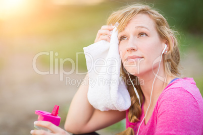 Young Fit Adult Woman Outdoors With Towel and Water Bottle in Wo