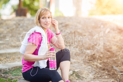 Young Fit Adult Woman Outdoors With Towel and Water Bottle in Wo