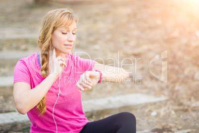 Young Fit Adult Woman Outdoors in Workout Clothes Listening To M