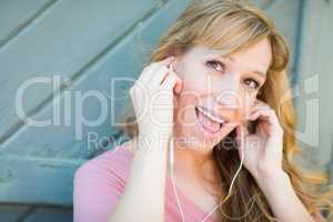 Outdoor Portrait of Young Adult Brown Eyed Woman Listening To Mu