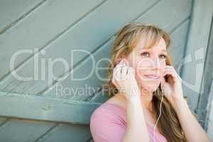 Outdoor Portrait of Young Adult Brown Eyed Woman Listening To Mu