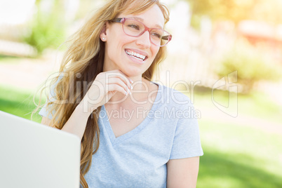Young Adult Woman Wearing Glasses Outdoors Using Her Laptop.